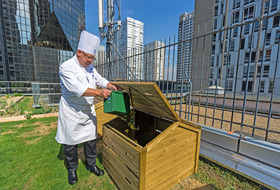 Chef disposes of compostable waste on the roof